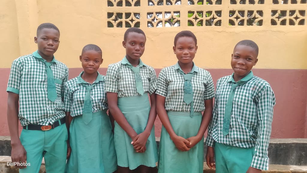 Chez Mican Schools students in uniform outside the classroom block