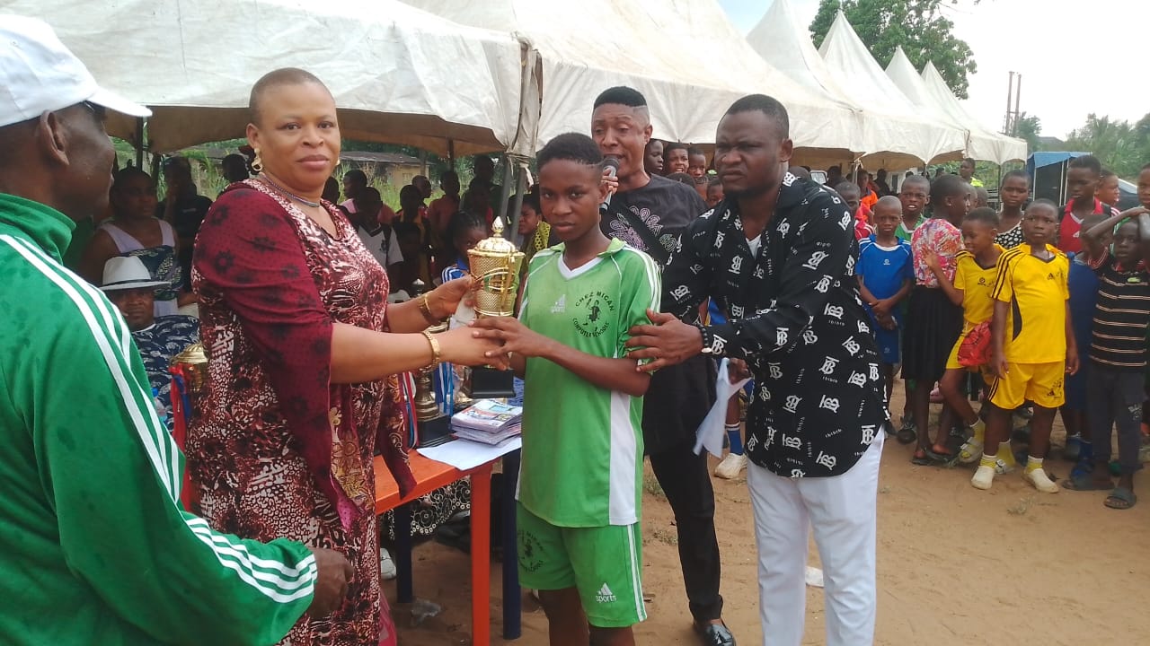 A student receiving a trophy at a Chez Mican Schools sports event